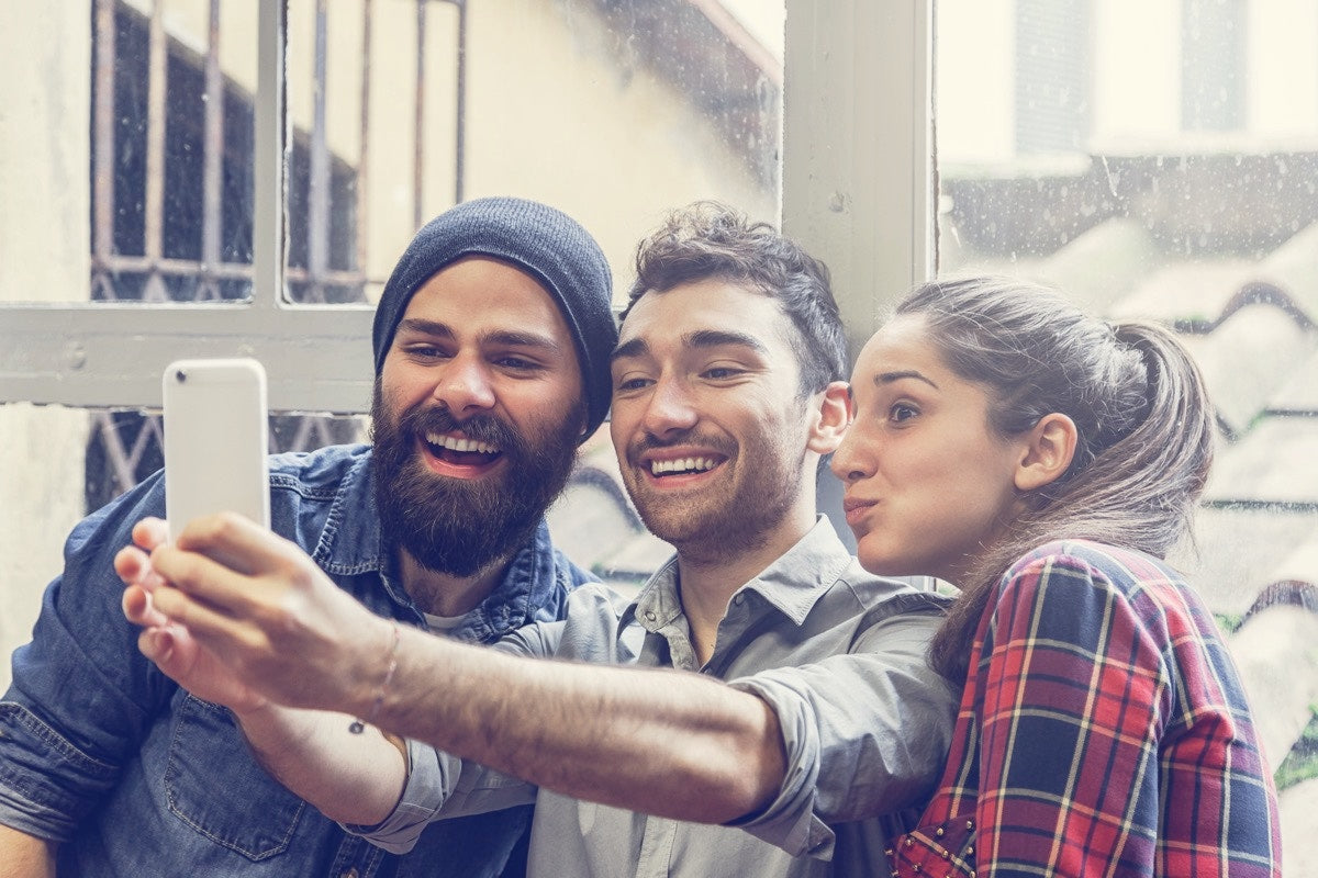 two men and a woman taking a selfie