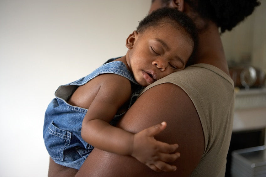 baby boy sleeping on mother's  shoulders