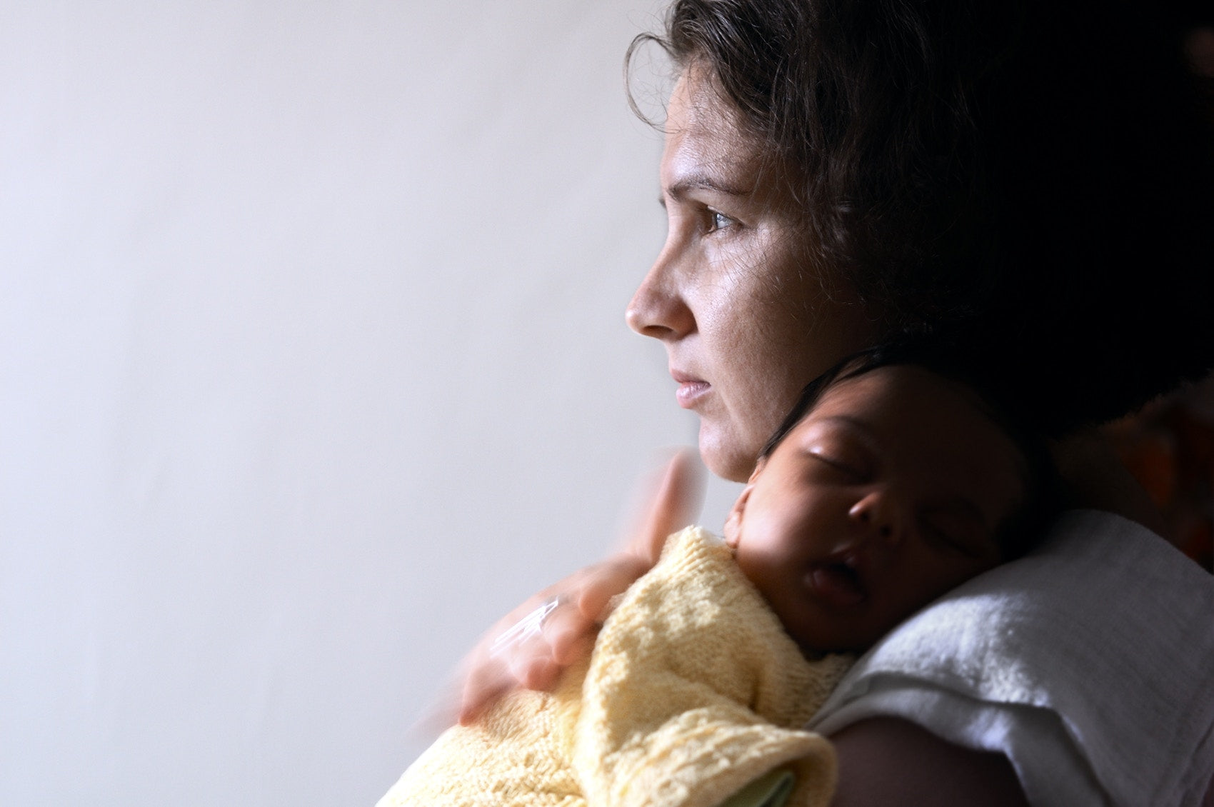 mother holding new born baby over shoulder