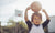 Child holding the basket ball on his head 