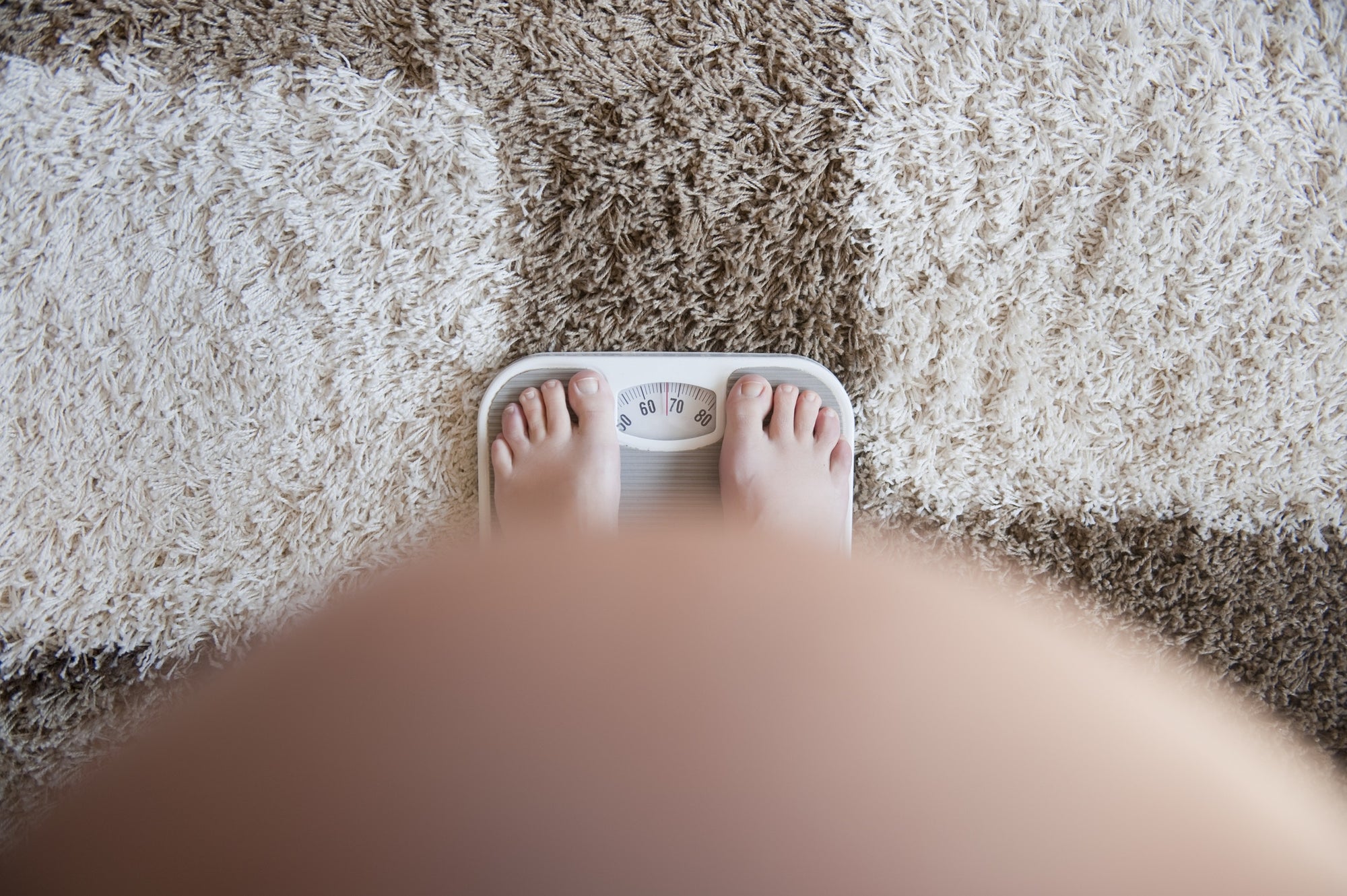 pregnant woman standing on weighing scales