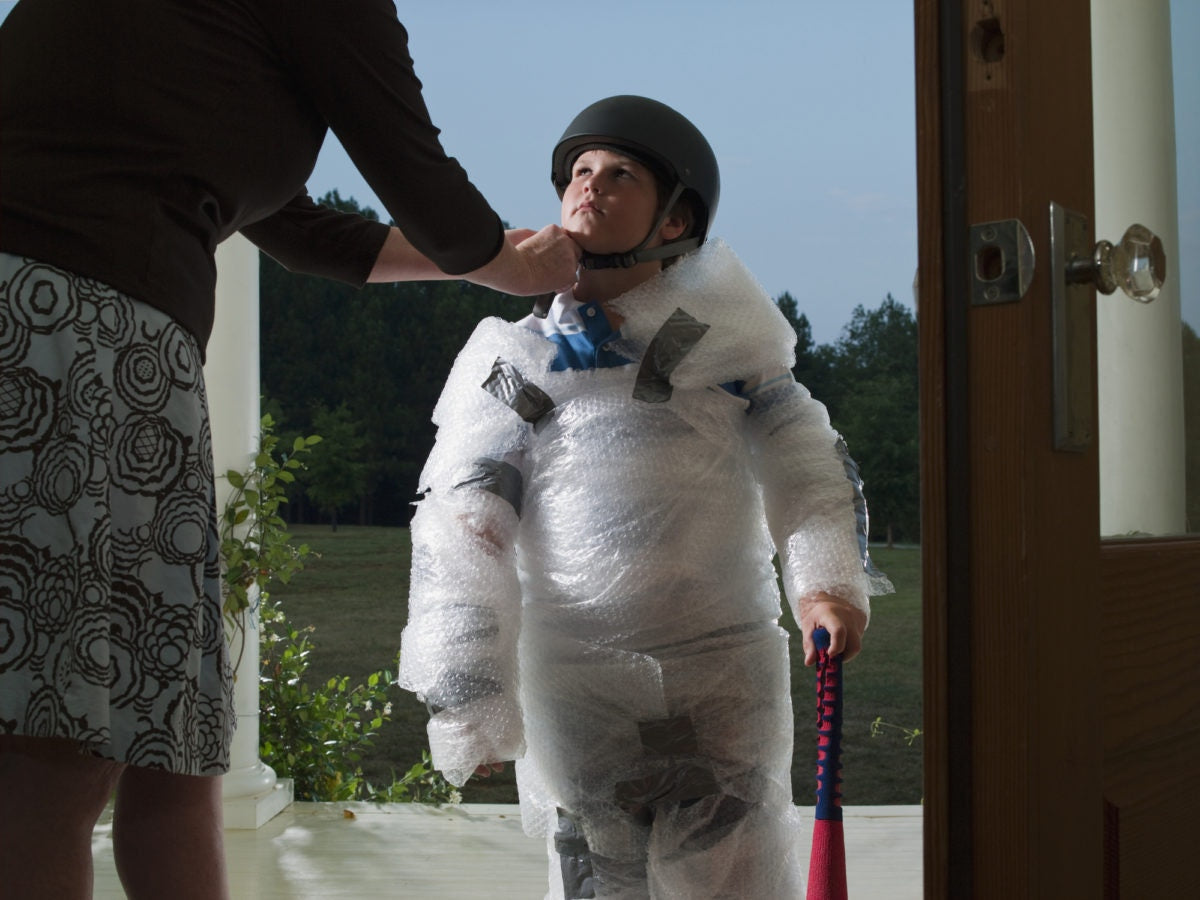 A mother is making ready to her son for a sporting event