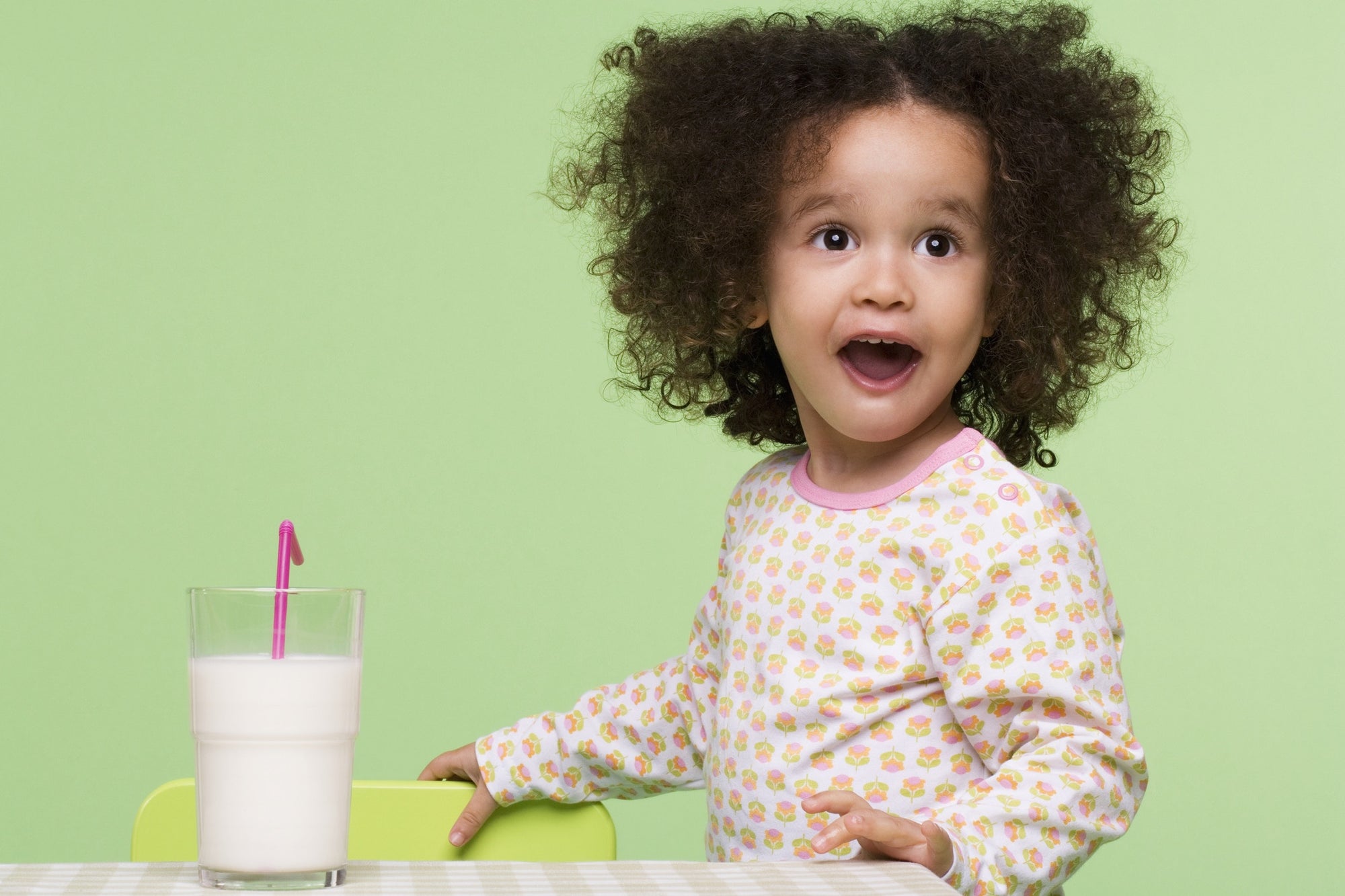 surprised little girl looking at a glass of milk