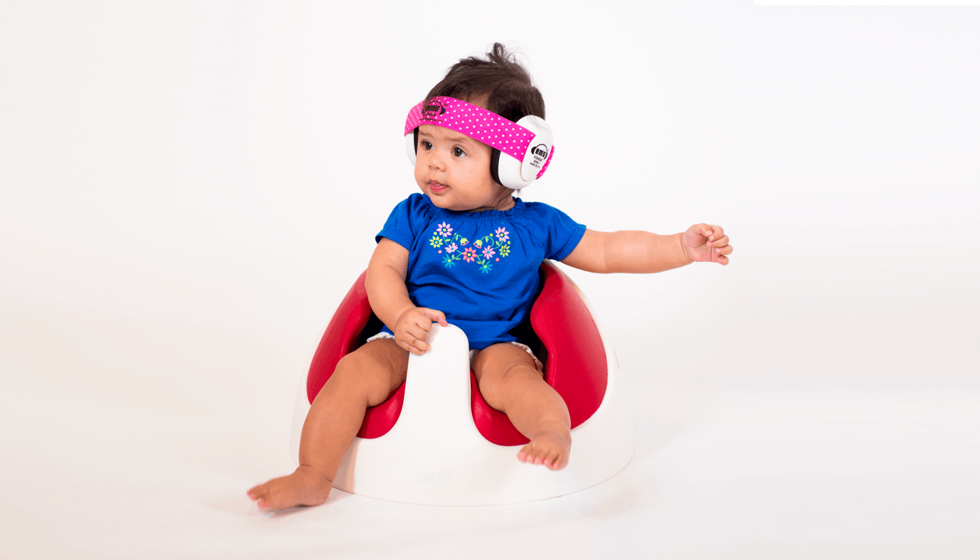 baby sitting in chair with ear muffs