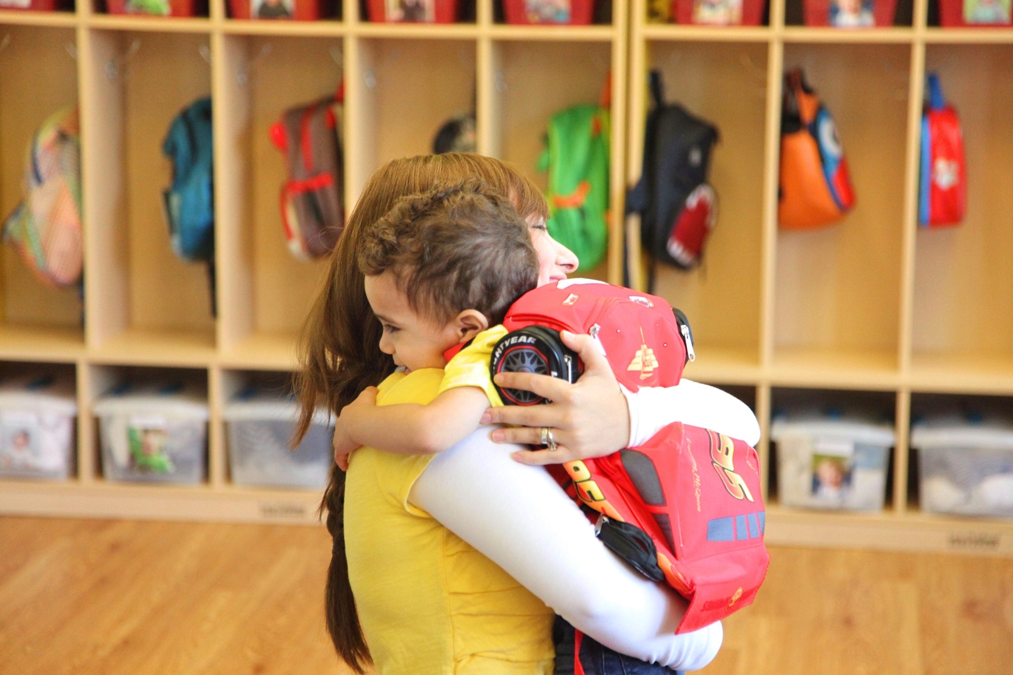 kid boy hugging mom at kindergarden