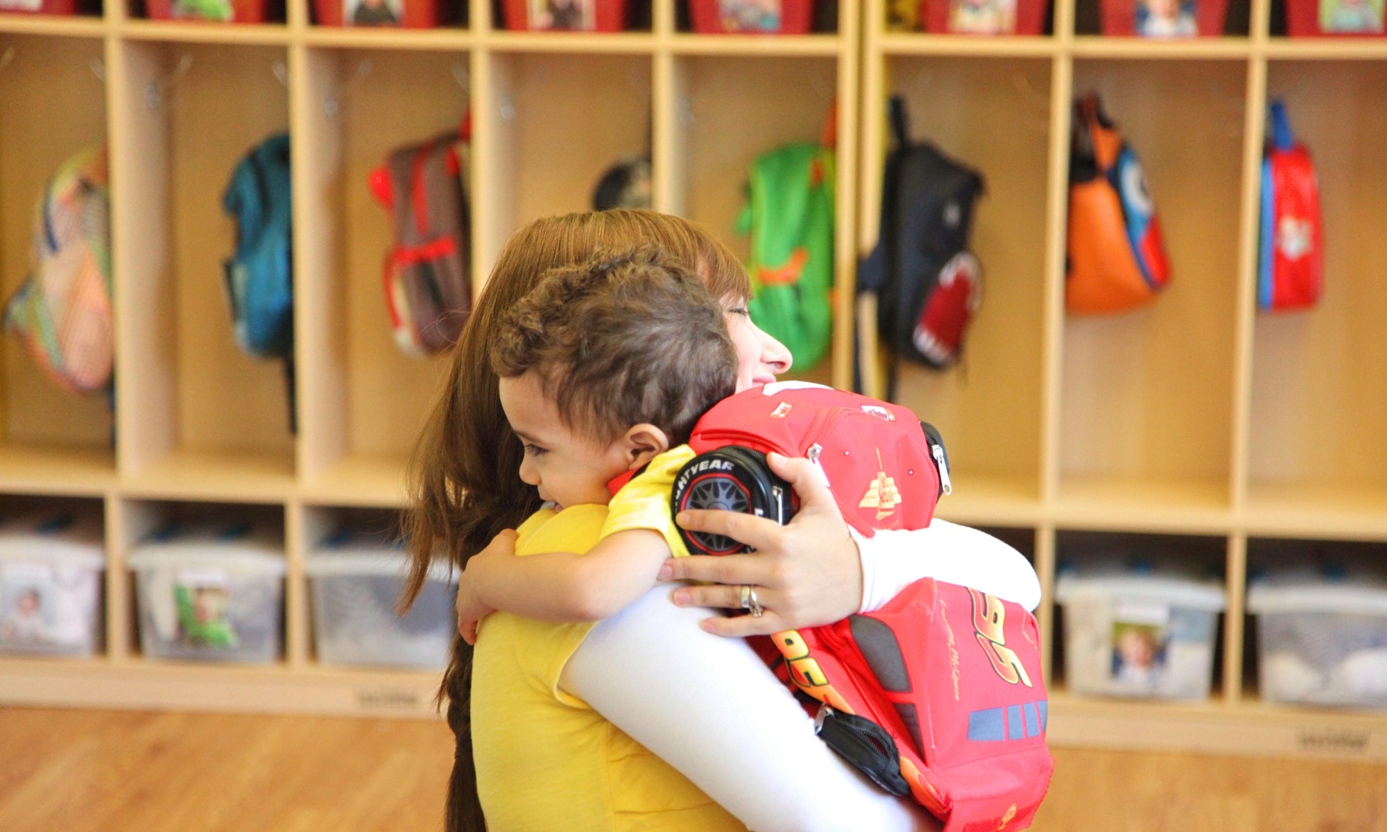 kid boy hugging mom at kindergarden