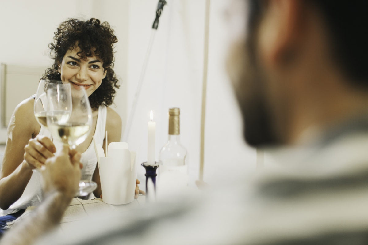 man and woman cheering a glass of wine