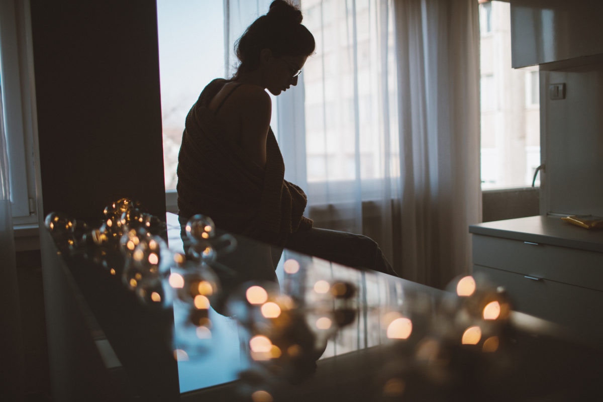 woman sitting in a kitchen looking down