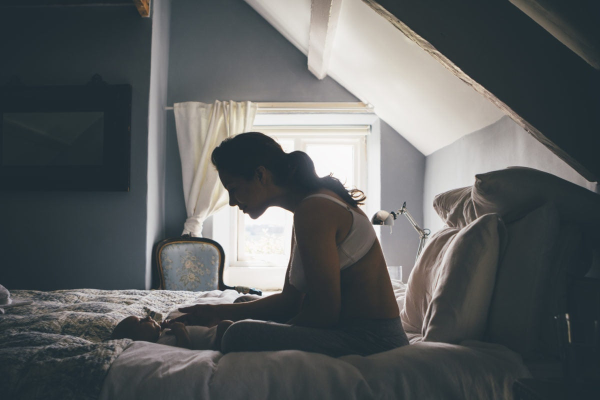 mom in bed looking at her baby