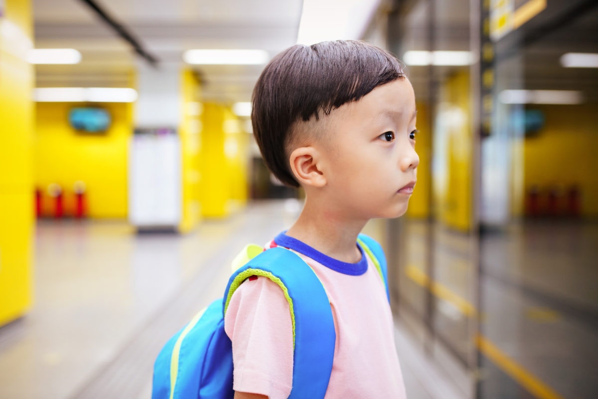 Japanese boy looking at something wearing school bag