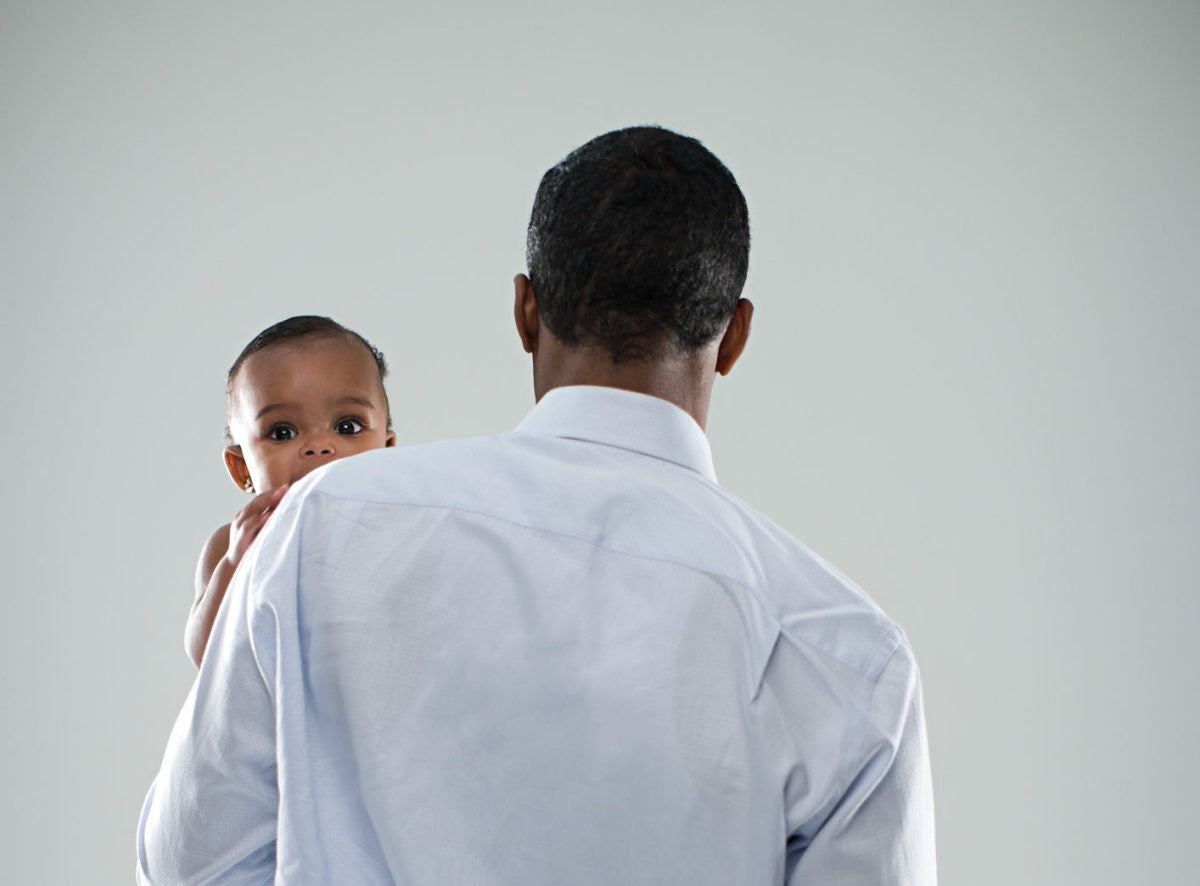 A father is holding a kid while kid is watching through back side