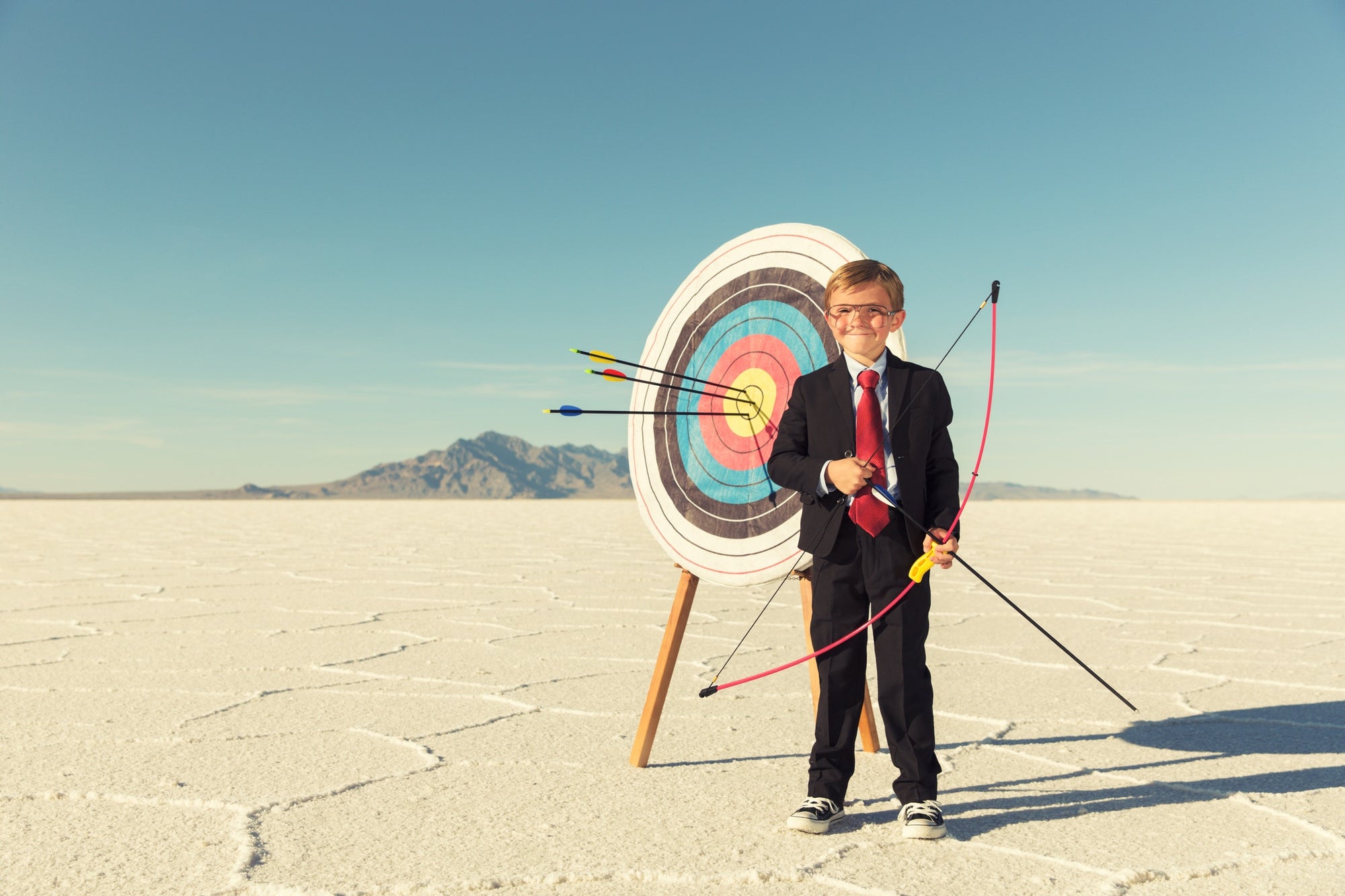 little boy with bow and arrow in snow background