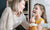 Mom and daughter smiling in kitchen with spoon