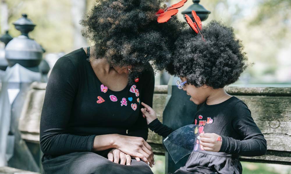 a child placing stickers on her mom