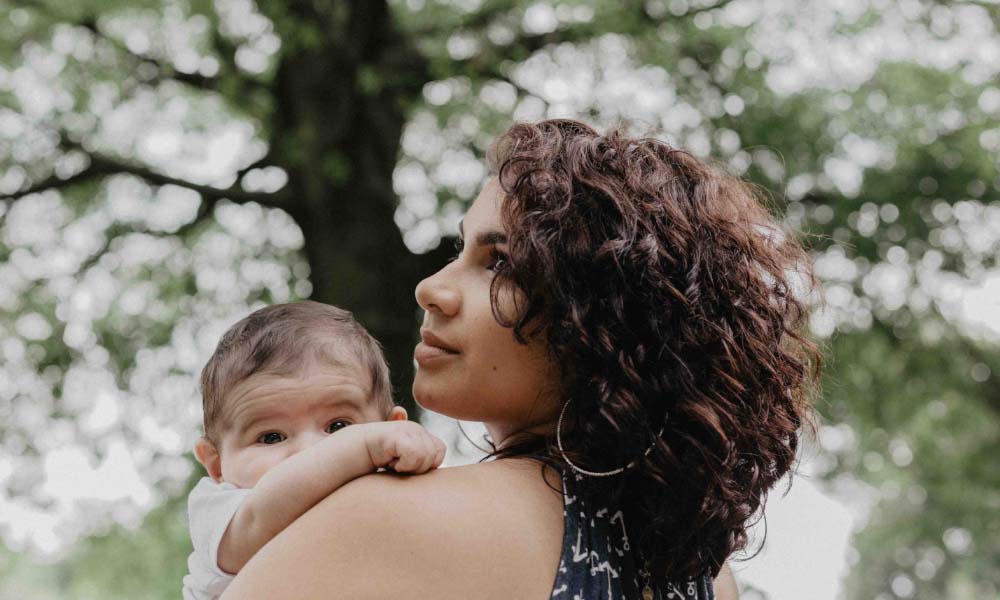 mom holding baby on shoulder