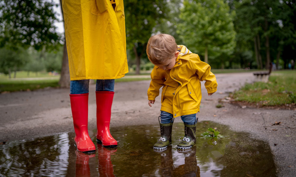 mother and son in rain coats holding