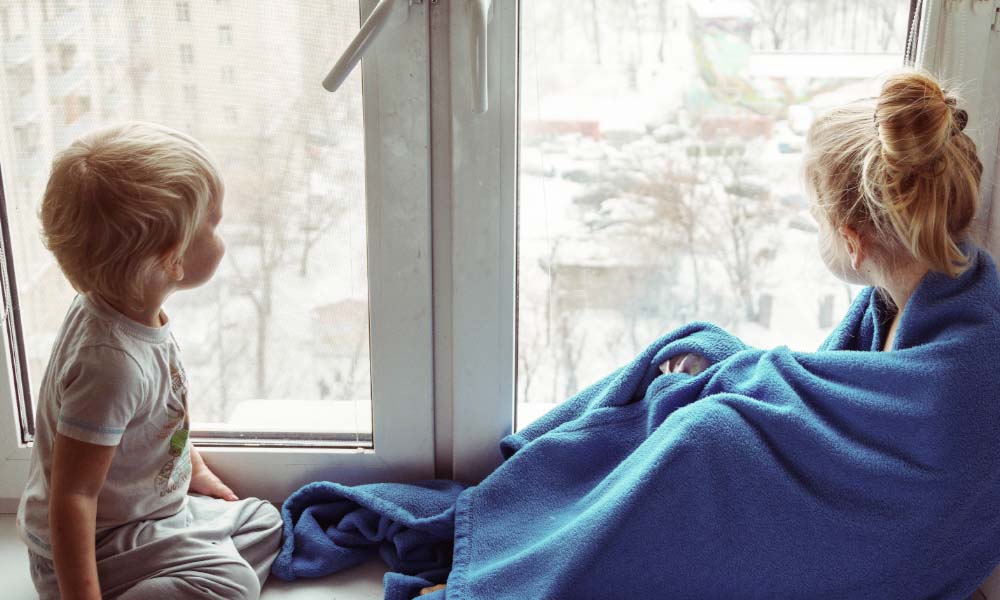 Two kids looking out the window 