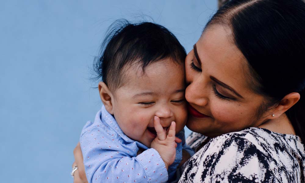 woman smiling holding baby boy